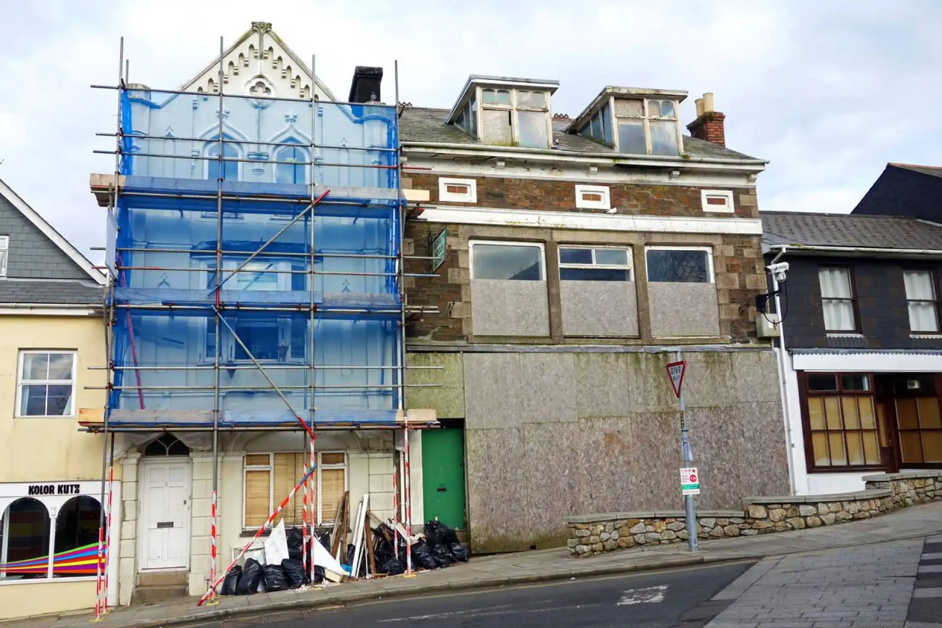 Maison en cours de rénovation avec échafaudages sous un ciel nuageux